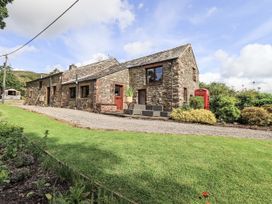 A stone house with a garden and a telephone booth at Chapel Cottage Ennerdale near Cleator Moor