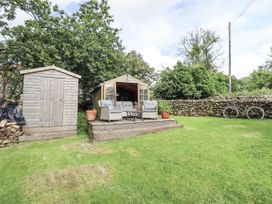 A garden with a shed, decking, seating area and bicycle at Chapel Cottage in Ennerdale near Cleator Moor