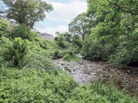 A stream surrounded by greenery and trees at Chapel Cottage Ennerdale near Cleator Moor