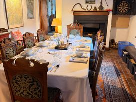 A dining room with a set dining table and a dartboard at Chapel Cottage Ennerdale