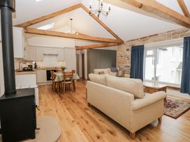A living room with a sofa and dining table at Swift Barn in Wigton