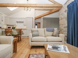A living room with a sofa and dining area at Swift Barn, Wigton