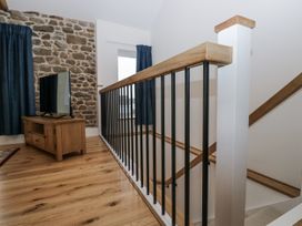 A stairway with a television and curtains at Swift Barn in Wigton