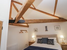 A bedroom with a bed and lamp at Swift Barn in Wigton