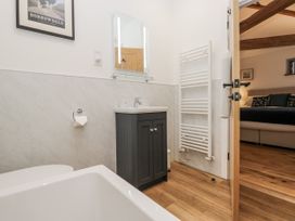 A bathroom with a bathtub, toilet, and vanity at Swift Barn in Wigton
