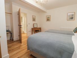 A bedroom with two beds and a table at Swift Barn in Wigton