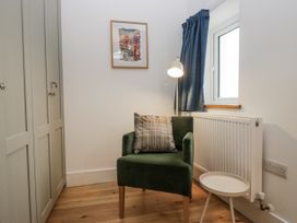 A study area with an armchair and a side table at Swift Barn in Wigton