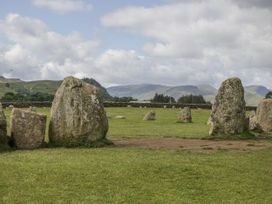 Standing stones in a grassy area with mountains in the background at Swift Barn, Wigton