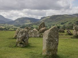 A field with standing stones and mountains in the background at Swift Barn Wigton