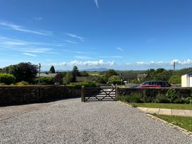 A driveway with a gate and cars at Swift Barn in Gilcrux