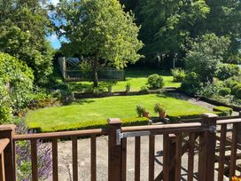 A garden with a lawn and flower pots at Swift Barn in Gilcrux