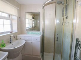 A bathroom with a sink hand wash cabinet mirror and enclosed shower at Kites - 52 Gower Holiday Village in Scurlage near Port Eynon and Rhossili
