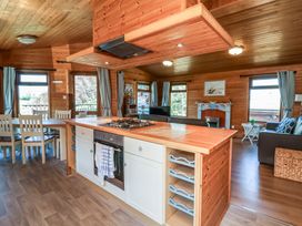 A kitchen with an island and dining area in a wooden cabin living room at The Beach House in Watermouth near Combe Martin