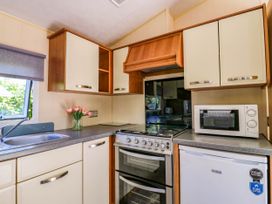 A kitchen with a sink stove microwave and refrigerator at Caravan 941 in Clacton-On-Sea