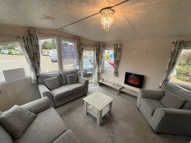 A living room with sofas and a wall-mounted fireplace at Caravan 941 in Clacton-On-Sea