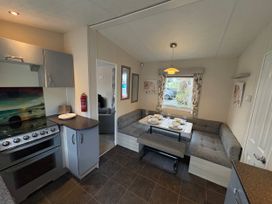 A kitchen with a stove and seating area at Caravan 941 in Clacton-On-Sea