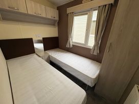 A bedroom with two single beds and a window at Caravan 941 Clacton-On-Sea