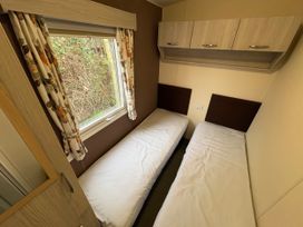 A bedroom with two single beds and a window at Caravan 941 Clacton-On-Sea