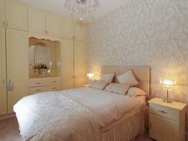 A bedroom with a bed pillows bedside tables lamps built in wardrobes and a mirror at Killelton Cottage Camp County Kerry