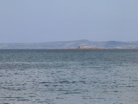 A body of water with a small island and lighthouse in the distance with hills in the background at Killelton Cottage Camp County Kerry