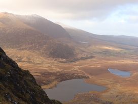 A mountainous landscape with lakes and a partly cloudy sky at Killelton Cottage in Camp County Kerry