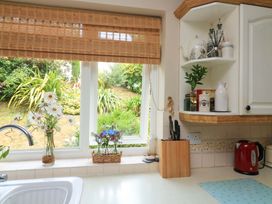 A kitchen with window and flowers on the counter at 3 Chantry Hill in Kingsbridge