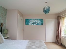 A bedroom with a bed, lamp and painting at 3 Chantry Hill in Kingsbridge