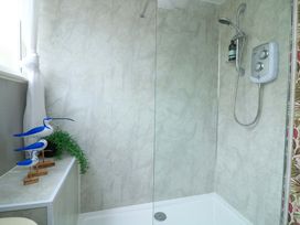 A shower area with decorative birds and a plant at 3 Chantry Hill in Kingsbridge