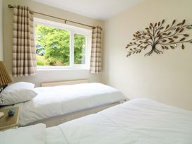 A bedroom with two beds and a window at 3 Chantry Hill in Kingsbridge