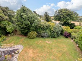 A garden with trees and a stone path at 3 Chantry Hill in Kingsbridge
