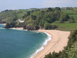 A beach with ocean waves and hills at 3 Chantry Hill in Kingsbridge