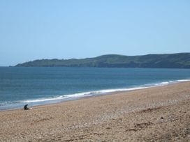 A beach with a person sitting on the sand at 3 Chantry Hill in Kingsbridge