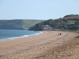 A beach with cliffs and people walking at 3 Chantry Hill in Kingsbridge