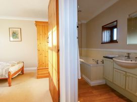 A bathroom with a bathtub and sink at The Coach House in Falmouth