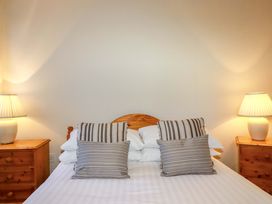 A bedroom with a bed and lamps at The Coach House in Falmouth