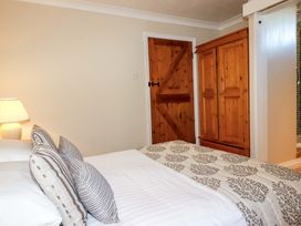 A bedroom with a bed and a wardrobe at The Coach House in Falmouth