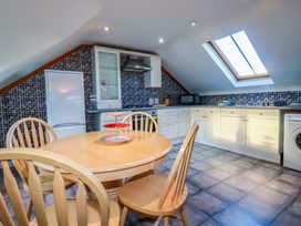 A kitchen with a table and chairs at The Coach House in Falmouth
