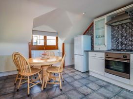 A kitchen with a table and chairs at The Coach House in Falmouth