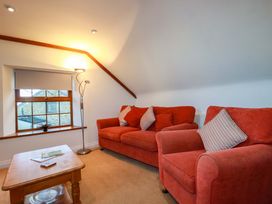 A living room with a sofa and coffee table at The Coach House in Falmouth