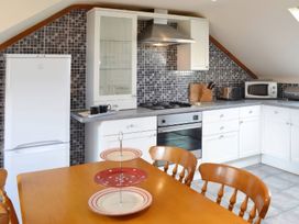 A kitchen with appliances and dining table at The Coach House Budock Water near Falmouth