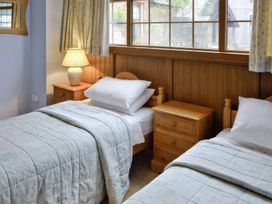 A bedroom with two beds and a nightstand at The Coach House Budock Water near Falmouth
