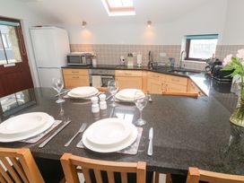A kitchen with appliances and dining setup at Tobys Quay in Falmouth