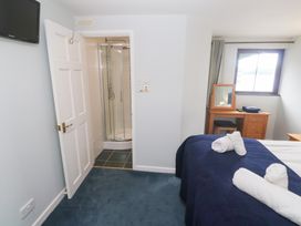 A bedroom with a bed and a shower room at Tobys Quay in Falmouth