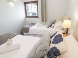A bedroom with two beds and a lamp at Tobys Quay in Falmouth