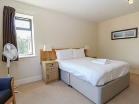A bedroom with a bed and fan at Bedroom 10 in Littlehampton