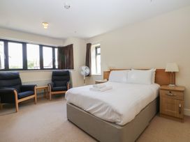 A bedroom with a bed and two chairs at Bedroom 10 in Littlehampton