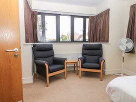 A bedroom with two chairs and a fan at Bedroom 10 Littlehampton