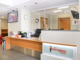 A reception area with a desk and information brochures at The Fire Fighters Charity in Littlehampton