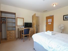 A bedroom with a bed, desk, and television at Bedroom 9 in Littlehampton