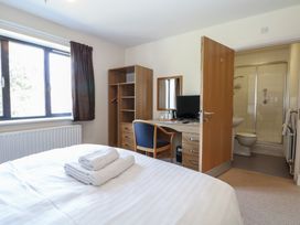 A bedroom with a bed, desk, and an en-suite bathroom at Bedroom 9 in Littlehampton